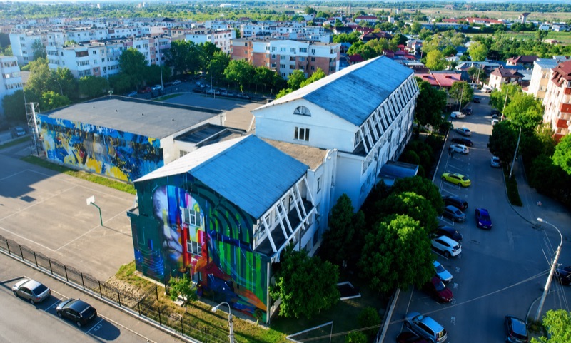 Vedere din aer a Liceului Teoretic de Informatică „Alexandru Marghiloman” din Buzău, cu murale colorate pe fațade.